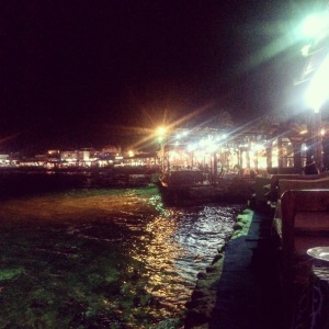 Dahab's restaurants seen at night from Sea House restaurant. It has tables overhanging the sea and the water is lit so you can see fish in it.
